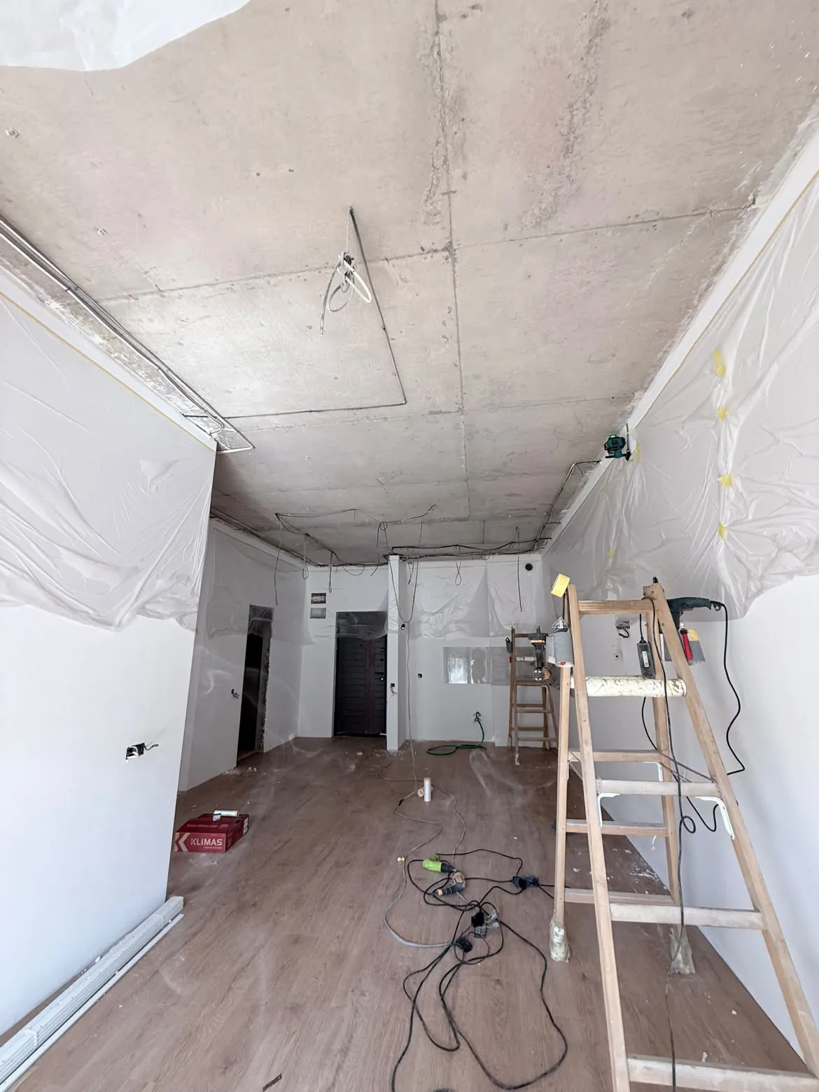 Bare concrete ceiling with loose wiring, before installation